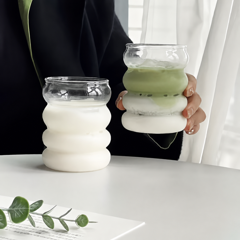 Rillede drikkeglas i borosilikat med sugerør – 2 stk. Dette sæt med rillede drikkeglas i borosilikat består af to dekorative glas med en bølget form, to genanvendelige glassugerør og en rensebørste. Glassene er velegnede til servering af iskaffe, juice, mælk, iste, vand og andre kolde drikke. Den afrundede, rillede overflade giver glassene et karakteristisk udtryk og gør dem behagelige at holde omkring. Hvert glas kan bruges med det medfølgende sugerør eller som et almindeligt drikkeglas uden sugerør. Nøglefordele Sæt med to rillede drikkeglas. Fremstillet i borosilikatglas. Leveres med to genanvendelige glassugerør. Rensebørste til rengøring af sugerørene medfølger. Velegnet til iskaffe, juice, mælk, iste og vand. Bølget overflade giver glassene et karakteristisk design. Afrundet drikkekant til almindelig servering uden sugerør. Kan bruges med isterninger, frugt og andre ingredienser. Velegnet til hjemmet, kontoret og servering for gæster. Genanvendeligt alternativ til engangskrus og engangssugerør. Glassene kan bruges samlet eller hver for sig. Ingen montering eller samling nødvendig. Oversigt Disse drikkeglas med glassugerør kombinerer en praktisk drikkefunktion med en dekorativ, rilleformet konstruktion. De vandrette forhøjninger skaber en blød og afrundet silhuet, som adskiller glassene fra traditionelle glas med lige sider. Sættet indeholder to glas, så de kan anvendes til servering for to personer eller bruges på forskellige tidspunkter i løbet af dagen. Det ene glas kan eksempelvis anvendes til iskaffe, mens det andet bruges til juice, mælk eller vand. De medfølgende sugerør er fremstillet i glas og har en bøjet top, som gør dem praktiske til servering direkte fra glasset. Rensebørsten kan føres gennem sugerørene efter brug og hjælper med at fjerne rester fra kaffe, mælk, juice og andre drikkevarer. Specifikationer Produkttype Rillede drikkeglas med sugerør Antal glas 2 stk. Materiale Borosilikatglas Konstruktion Enkeltlagsglas Form Rund og bølget Håndtag Nej Antal sugerør 2 stk. Sugerørsmateriale Glas Tilbehør Rensebørste til sugerør Anvendelse Iskaffe, juice, mælk, iste, vand og andre kolde drikke Brugsområde Hjem, kontor, spisebord og servering Pakkeindhold 2 drikkeglas, 2 glassugerør og 1 rensebørste Rillet og bølget design Glassene har en overflade med flere afrundede forhøjninger, som skaber et bølget udtryk. Formen gør glassene dekorative på spisebordet, kaffebordet eller en serveringsbakke. De vandrette riller giver samtidig flere kontaktpunkter, når glasset holdes omkring midten. Det kan gøre det lettere at bevare et stabilt greb, når ydersiden er tør. Den rillede form fremhæver drikkens indhold og gør glassene velegnede til drikke med synlige lag, isterninger, mælk, kaffe, frugt eller urter. Sæt med to drikkeglas Pakken indeholder to ens drikkeglas, som kan bruges sammen eller hver for sig. Sættet passer til servering for to personer og kan anvendes ved både hverdagsmåltider og besøg. Glassene kan eksempelvis bruges til: Iskaffe til to personer. Juice ved morgenbordet. Mælk eller plantedrikke. Vand til frokost og aftensmad. Iste og andre afkølede drikke. Kolde drikke ved brunch. Servering af forskellige drikke på samme tid. Når begge glas ikke er i brug, kan det ene opbevares som reserve. Genanvendelige glassugerør Der medfølger et glassugerør til hvert drikkeglas. Sugerørene har en bøjet øvre del, som giver en praktisk drikkevinkel, når de placeres i glassene. Glassugerørene kan anvendes til: Iskaffe. Iste. Juice. Mælk og plantedrikke. Vand med frugt eller urter. Lemonade. Andre kolde drikke uden store frugtstykker. Glassugerør er beregnet til gentagen brug og kan rengøres efter hver servering. Kontrollér altid sugerøret for revner eller skår, inden det placeres i glasset. Rensebørste til sugerørene Den medfølgende rensebørste er udformet til at komme ind gennem glassugerørenes smalle åbning. Børsten hjælper med at fjerne væske og rester, som ikke altid kan skylles væk med vand alene. Rensebørsten kan bruges efter drikke med: Kaffe. Mælk. Juice. Sirup. Te. Frugt og urter. Skyl sugerørene umiddelbart efter brug, så rester ikke tørrer fast indvendigt. Til iskaffe og kolde kaffedrikke Glassene er velegnede til iskaffe med isterninger, mælk og afkølet kaffe. Glassets åbne konstruktion gør det nemt at tilføje ingredienser og røre drikken sammen. De kan blandt andet bruges til: Iskaffe med mælk. Cold brew. Afkølet espresso med isterninger. Kaffe med mælkeskum. Kolde kaffedrikke med sirup. Iskaffe med plantedrik. Tilføj først isterninger og mælk, og hæld derefter den afkølede kaffe over for at skabe synlige lag i glasset. Til juice og iste Sættet kan bruges til juice, iste og andre kolde drikke ved morgenmad, brunch eller almindelige måltider. Mulige serveringer omfatter: Appelsinjuice. Æblejuice. Frugtjuice. Iste med isterninger. Lemonade. Vand med citrusfrugt. Afkølet te med urter. Undgå meget store frugtstykker, hvis drikken indtages gennem sugerøret, da de kan blokere åbningen. Til mælk og plantedrikke Drikkeglassene kan også bruges til mælk, kakaodrikke og forskellige plantedrikke. Den rillede form giver glassene et dekorativt udtryk ved morgenbordet eller under en kaffepause. De kan eksempelvis bruges til: Mælk. Havredrik. Mandeldrik. Sojadrik. Kolde kakaodrikke. Mælk med kaffe eller sirup. Skyl glassene og sugerørene kort efter brug, så rester fra mælk og lignende drikke ikke tørrer fast. Til vand og drikke med isterninger Glassene kan anvendes som almindelige vandglas med eller uden sugerør. Den åbne top giver plads til isterninger, frugtskiver og mindre urter. Vand kan blandt andet serveres med: Isterninger. Citrusfrugt. Agurkeskiver. Bær. Mynte og andre urter. Lad lidt plads være ved kanten, så drikken ikke løber over, når isterninger eller frugt tilsættes. Borosilikatglas til gentagen brug Glassene og sugerørene er fremstillet i borosilikatglas. Materialet giver et let og enkelt drikkesæt, som kan genanvendes til mange forskellige kolde drikke. Selvom borosilikatglas er beregnet til gentagen anvendelse, skal delene stadig håndteres som almindelige glasprodukter. Hårde slag, fald og kraftigt tryk kan beskadige både glas og sugerør. Undgå at: Slå glassene mod vasken eller andet service. Presse sugerørene hårdt mod glassets bund. Bruge glassene, hvis de har revner eller skår. Udsætte glasset for pludselige temperaturskift. Placere glassene tæt på kanten af bordet. Enkeltlagsglas uden håndtag Glassene har en enkeltlagskonstruktion og er udformet uden håndtag. De løftes ved at holde omkring den midterste eller nederste del. Kondens fra kolde drikke kan gøre ydersiden fugtig. Tør derfor eventuelt glasset af, før det løftes, og brug en bordskåner for at opsamle fugt på bordet. Sættet er beregnet til almindelig servering på bordet og er ikke udformet som en lukket transportkop. Til morgenbordet og kaffepausen De to glas kan bruges ved morgenmad, brunch, frokost eller en almindelig kaffepause. De kan placeres direkte på bordet eller serveres på en bakke sammen med kande, kaffebrygger eller andre drikkevarer. Mulige placeringer omfatter: Spisebordet. Køkkenbordet. Et sidebord ved sofaen. En kaffestation. Et serveringsbord. En bakke til morgenmad eller brunch. Placér glassene på en plan og stabil overflade med passende afstand til bordets kant. Drikkeglas til kontoret Glassene kan anvendes til vand, juice eller iskaffe på kontoret og hjemmearbejdspladsen. Det genanvendelige sæt kan opbevares i et fælleskøkken eller ved en kaffestation. Ved brug på skrivebordet bør glasset stå med afstand til: Bærbar computer. Tastatur og mus. Opladere og stikdåser. Dokumenter og notesbøger. Andre genstande, som kan tage skade af væske. Brug eventuelt en bordskåner under glasset for at beskytte bordoverfladen mod kondens. Til servering for gæster Sættet med to glas er velegnet til servering ved besøg, brunch, dessert eller mindre sammenkomster. Glassene kan fyldes med samme drik eller bruges til to forskellige serveringer. De kan blandt andet anvendes ved: Morgenmad og brunch. Eftermiddagskaffe. Dessertservering. Mindre sammenkomster. Film- og spilleaftener. Servering af kolde drikke ved måltider. Glassene kan kombineres med en kande, serveringsbakke og bordskånere for at skabe en samlet servering. Sådan bruges drikkeglassene Kontrollér, at glas og sugerør er rene og uden skader. Placér glasset på en plan og stabil overflade. Tilføj eventuelt isterninger. Hæld den ønskede kolde drik i glasset. Lad lidt plads være mellem drikken og kanten. Placér glassugerøret forsigtigt i glasset. Undgå at slå sugerøret hårdt mod bunden eller kanten. Rengør alle dele efter brug. Rør drikken forsigtigt, så sugerøret ikke presses mod glassets sider. Rengøring af glassene Rengør glassene med lunkent vand, mildt opvaskemiddel og en blød svamp. Skyl dem grundigt, så alle sæberester fjernes. Følg disse trin: Fjern sugerøret fra glasset. Skyl rester fra drikken væk. Rengør indersiden med en blød svamp. Skyl glasset med rent vand. Tør det forsigtigt med et blødt viskestykke. Placér glasset stabilt under lufttørring. Undgå at anvende stor kraft omkring den rillede overflade og drikkekanten. Rengøring af glassugerørene Skyl sugerørene umiddelbart efter brug. Før derefter den medfølgende rensebørste gennem hele sugerøret. Sådan rengøres sugerørene: Skyl sugerøret med lunkent vand. Påfør lidt mildt opvaskemiddel på rensebørsten. Før børsten forsigtigt gennem sugerøret. Bevæg børsten frem og tilbage. Skyl sugerøret grundigt med rent vand. Lad det tørre stående eller liggende på et sikkert underlag. Kontrollér sugerøret efter rengøring, før det anvendes igen. Rengøring og vedligeholdelse Regelmæssig rengøring hjælper med at fjerne rester fra kaffe, mælk, juice og andre drikkevarer. Skyl delene kort efter brug, så indholdet ikke tørrer fast. Undgå at anvende: Ståluld og grove skuresvampe. Skarpe skrabere. Hårde rengøringsbørster på glassenes overflade. Kraftige opløsningsmidler. Unødvendigt stort tryk under aftørring. Redskaber, som kan ridse glasset. Kontrollér jævnligt både glas, drikkekanter og sugerør for revner eller skår. Sikker brug af glassugerør Glassugerør skal håndteres forsigtigt. Bid ikke i sugerøret, og brug det ikke, hvis der er synlige skader. Ved brug bør du: Placere sugerøret roligt i glasset. Undgå at presse det mod bunden. Undgå at slå det mod drikkekanten. Kontrollere det før hver anvendelse. Opbevare det sikkert mellem brug. Stoppe brugen ved revner eller skår. Produktet indeholder skrøbelige glasdele og bør anvendes under passende opsyn, når børn er til stede. Sikker placering Placér glassene på et stabilt underlag, hvor de ikke let kan væltes. Undgå placering tæt på kanter, hvor de kan blive ramt eller skubbet ned. Glassene bør ikke placeres direkte ved: Kanten af borde og hylder. Åben ild. Tændte kogeplader. Varme ovnlåger. Ustabile eller skrå overflader. Områder med risiko for hårde slag. Brug ikke glas eller sugerør, som har været tabt, uden først at kontrollere dem grundigt for skader. Opbevaring mellem brug Alle dele skal være rene og tørre før opbevaring. Glassene kan opbevares stående i et skab eller på en stabil hylde. Sugerørene kan opbevares: Liggende i en skuffe med passende beskyttelse. Stående i en beholder. Sammen med andet genanvendeligt drikketilbehør. På et sted, hvor de ikke kan rulle ned. Undgå at placere tunge genstande oven på glassene eller sugerørene. Pakkeindhold 2 rillede drikkeglas i borosilikatglas. 2 genanvendelige glassugerør. 1 rensebørste til sugerørene. Drikkevarer, isterninger, frugt, bordskånere og øvrige viste serveringsgenstande medfølger ikke. Rillede drikkeglas til iskaffe, juice og mælk Dette sæt med to rillede drikkeglas i borosilikat giver en dekorativ og genanvendelig løsning til servering af iskaffe, juice, mælk, iste, vand og andre kolde drikke. Der medfølger to bøjede glassugerør og en rensebørste, så sugerørene kan rengøres efter brug. Den bølgede form giver glassene et karakteristisk udtryk og gør sættet velegnet til både daglig brug, kontoret og servering for gæster.