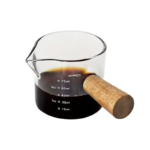 Varmebestandigt målebæger i glas med træhåndtag, måleskala og hældetud til espresso, mælk, sirup og sauce