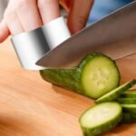 Stainless steel finger guard protecting fingers while slicing cucumber