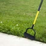 Half-moon lawn edger cutting along a path edge