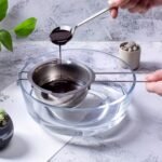 Stainless steel chocolate melting bowl resting over a glass bowl