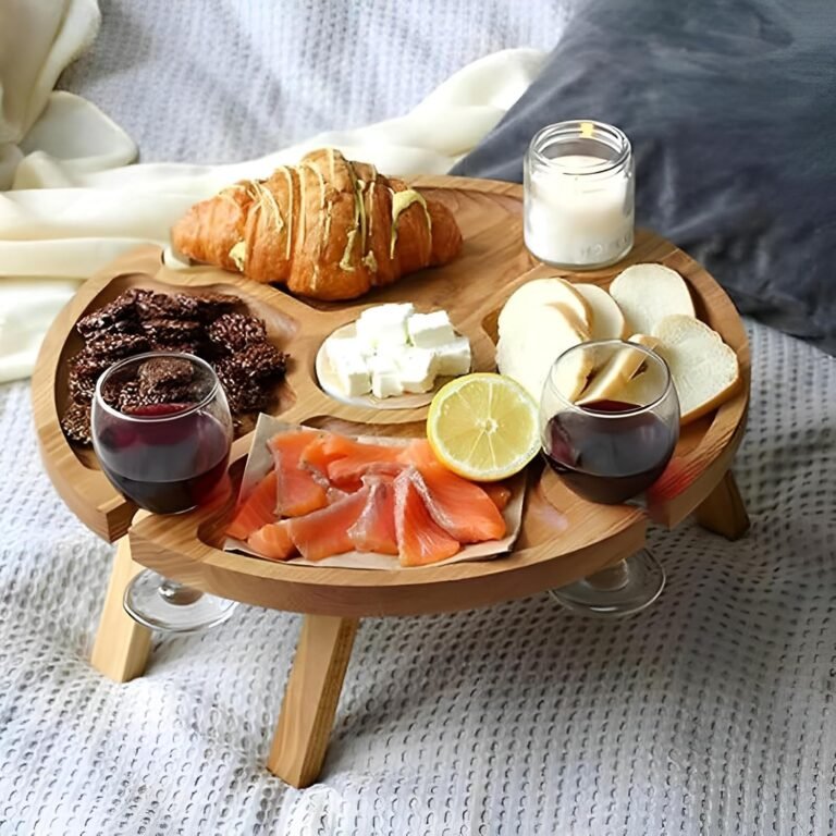 Round wooden picnic wine table with cheese and wine on a blanket
