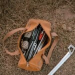 Canvas tent peg storage bag with pegs and rope on the grass