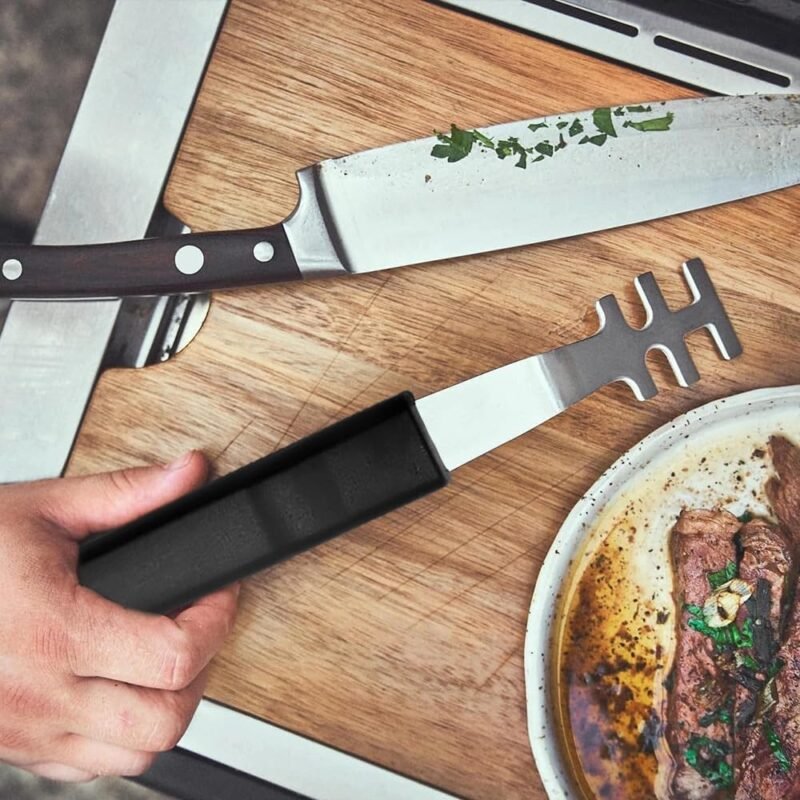 Grill grate lifter on a wooden chopping board next to a steak