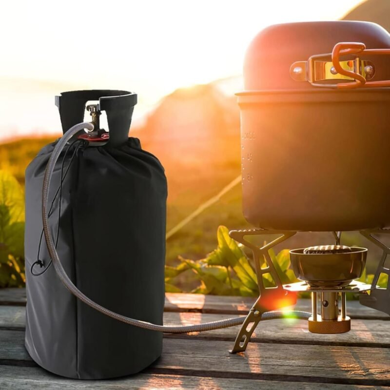 Black gas bottle cover on a cylinder outdoors next to a camping stove