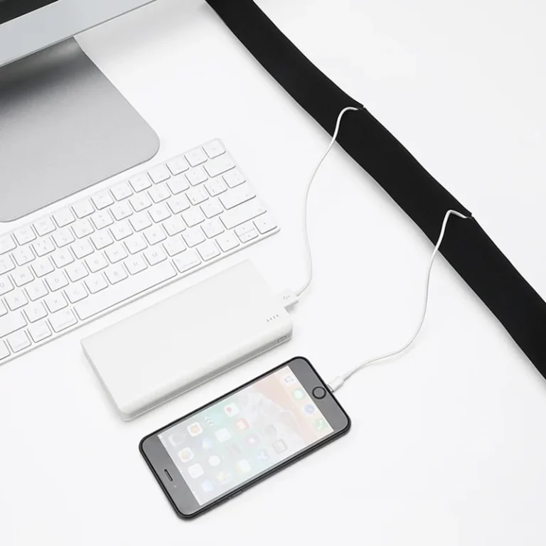 Black cable sleeve tidying cables under a desk