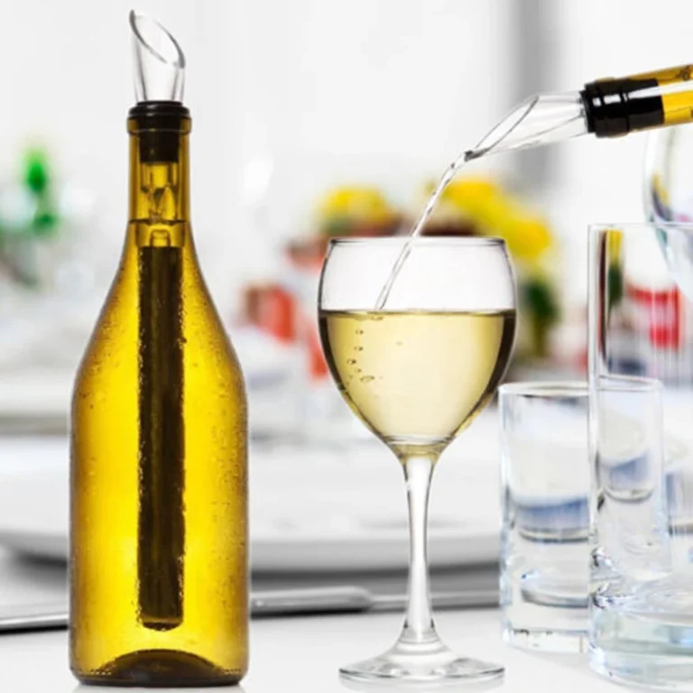 Stainless steel wine chiller stick in a white wine bottle with a glass of wine