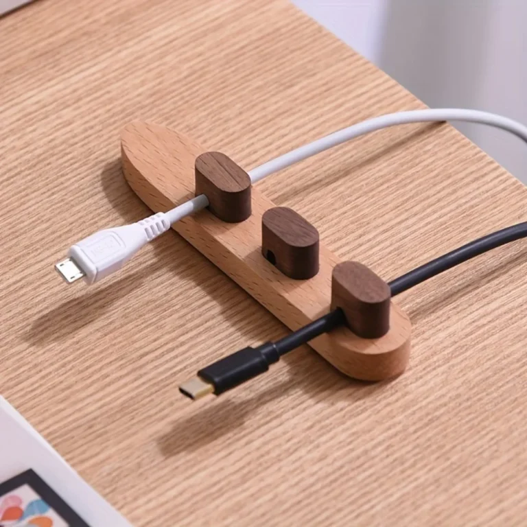 Wooden cable organiser holding charging cables on a desk