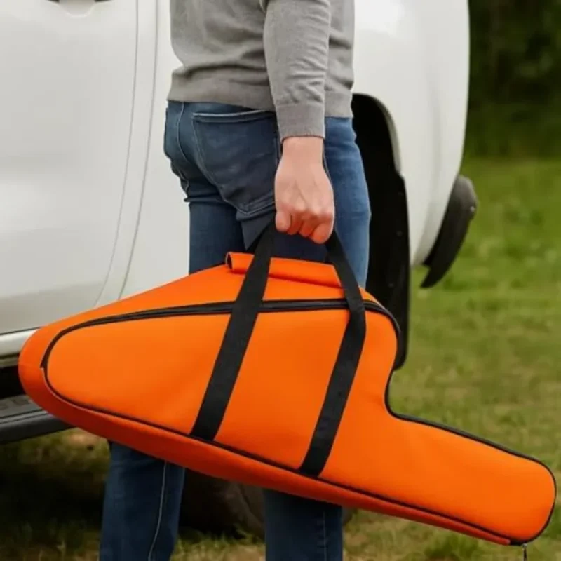 Orange chainsaw carry bag being carried outdoors