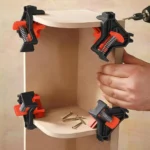 Orange 90-degree corner clamps holding a wooden shelf during assembly