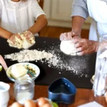 Large black worktop chopping board used for kneading dough