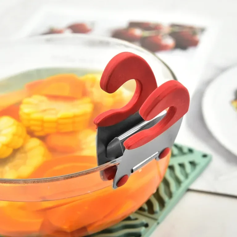 Red and steel pot clip holding a spoon on the rim of a bowl