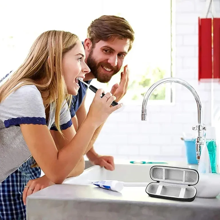 Black hard toothbrush travel case open on a bathroom counter
