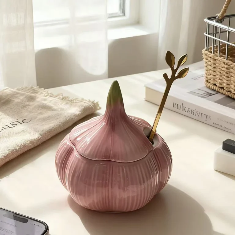 Pink garlic-shaped ceramic jar with lid on a kitchen worktop