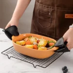 Black silicone pinch grips used to lift a hot baking dish in the kitchen