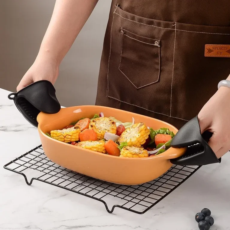 Black silicone pinch grips used to lift a hot baking dish in the kitchen