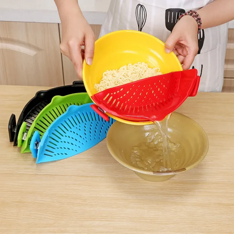 Red clip-on silicone strainer draining noodles from a bowl