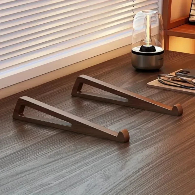 Two wooden laptop stand pieces on a desk by a window