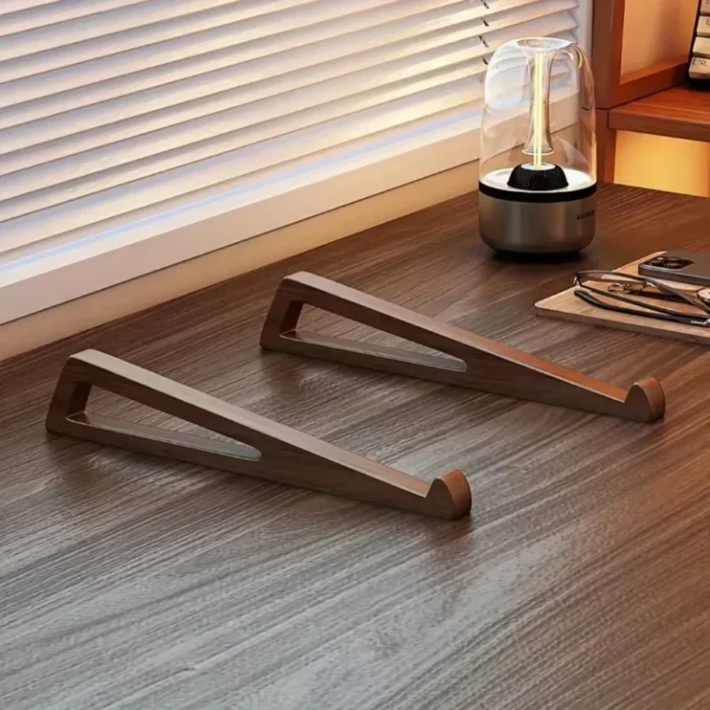 Two wooden laptop stand pieces on a desk by a window