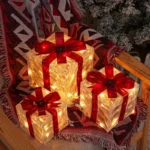 Three light-up gift boxes with red bows glowing on a chair with a blanket