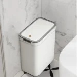 White bathroom bin with grey-rimmed lid in a bathroom corner