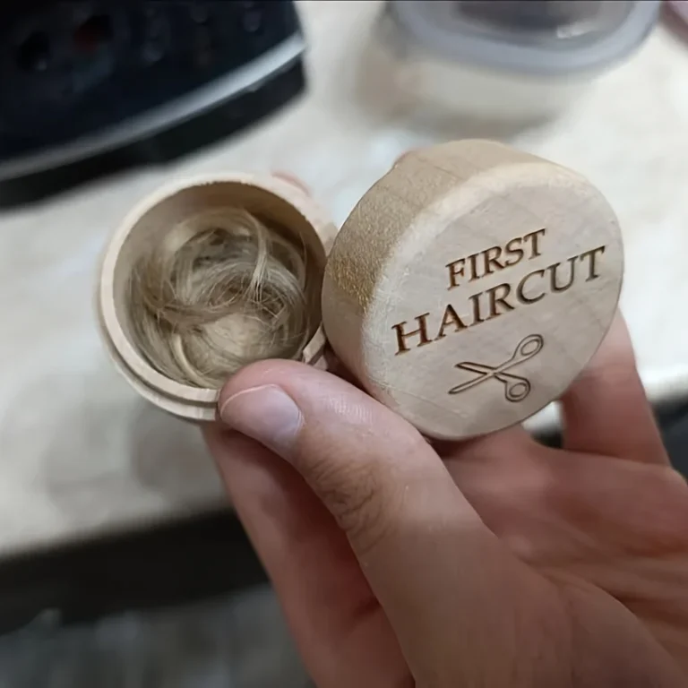 Open wooden first haircut box holding a lock of baby hair