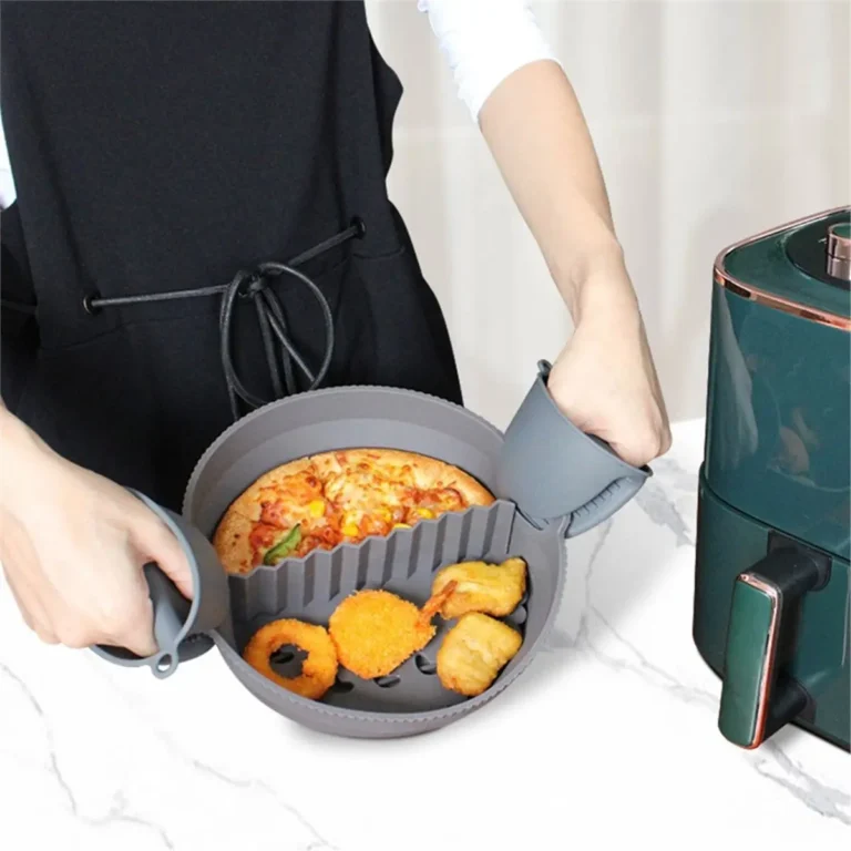 Grey silicone air fryer liner with food lifted out next to an air fryer