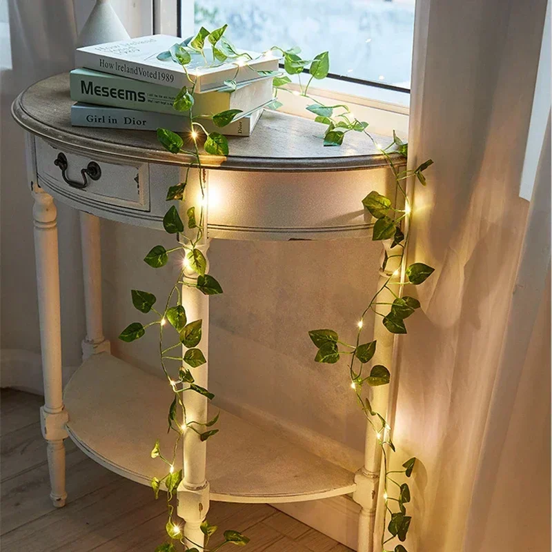 Artificial ivy fairy lights draped over a white side table