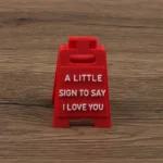 Red mini sign saying 'A little sign to say I love you' on a wooden table
