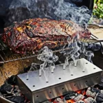 Perforated stainless steel smoker box on hot coals under a smoking joint of meat