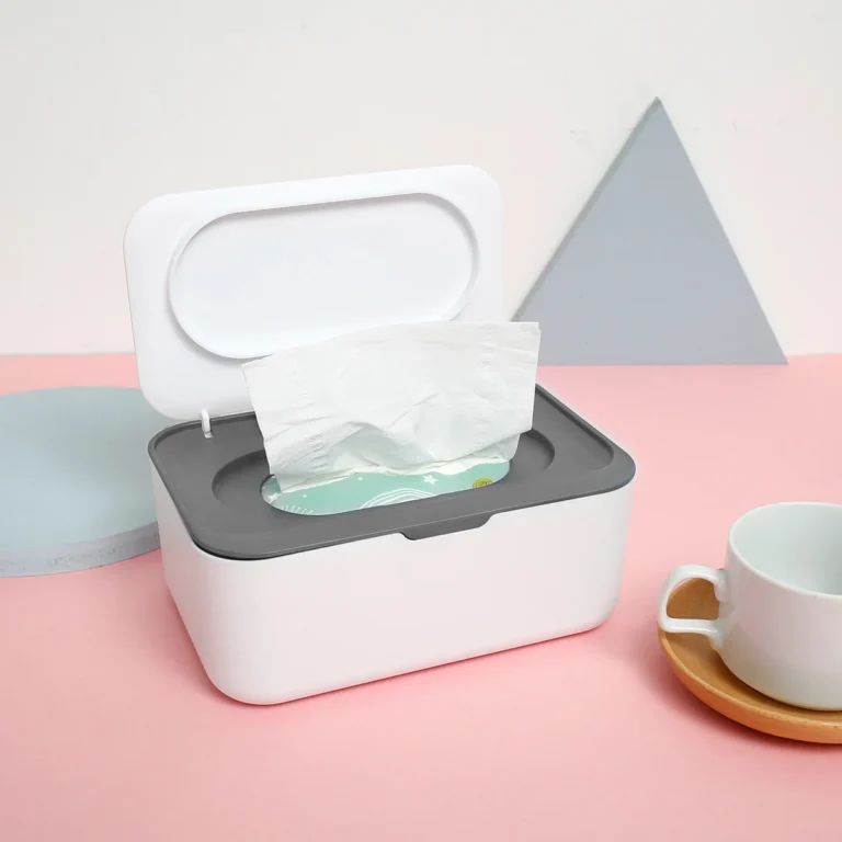 White wet wipe box with grey lid on a table next to a cup