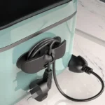 Black cable organiser holding a power cord on a kitchen appliance