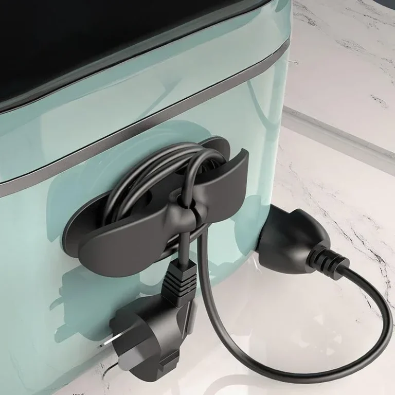 Black cable organiser holding a power cord on a kitchen appliance