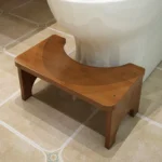 Brown bamboo toilet stool in front of toilet