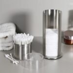 Cotton bud holder with buds and pads in the bathroom