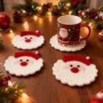 Crochet Santa coasters on a Christmas table with a mug and fairy lights